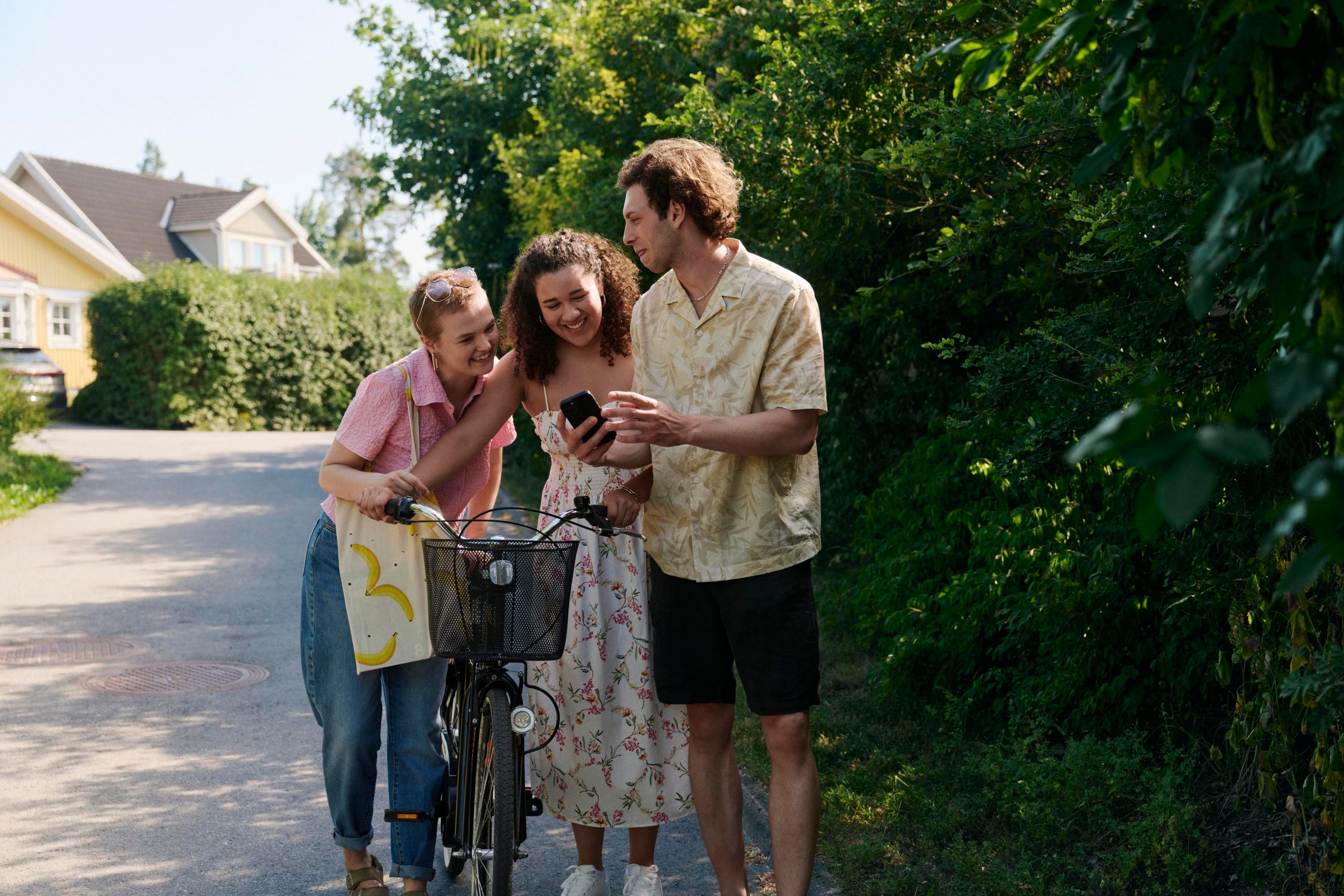 Tre unga vuxna tittar i en mobil tillsammans