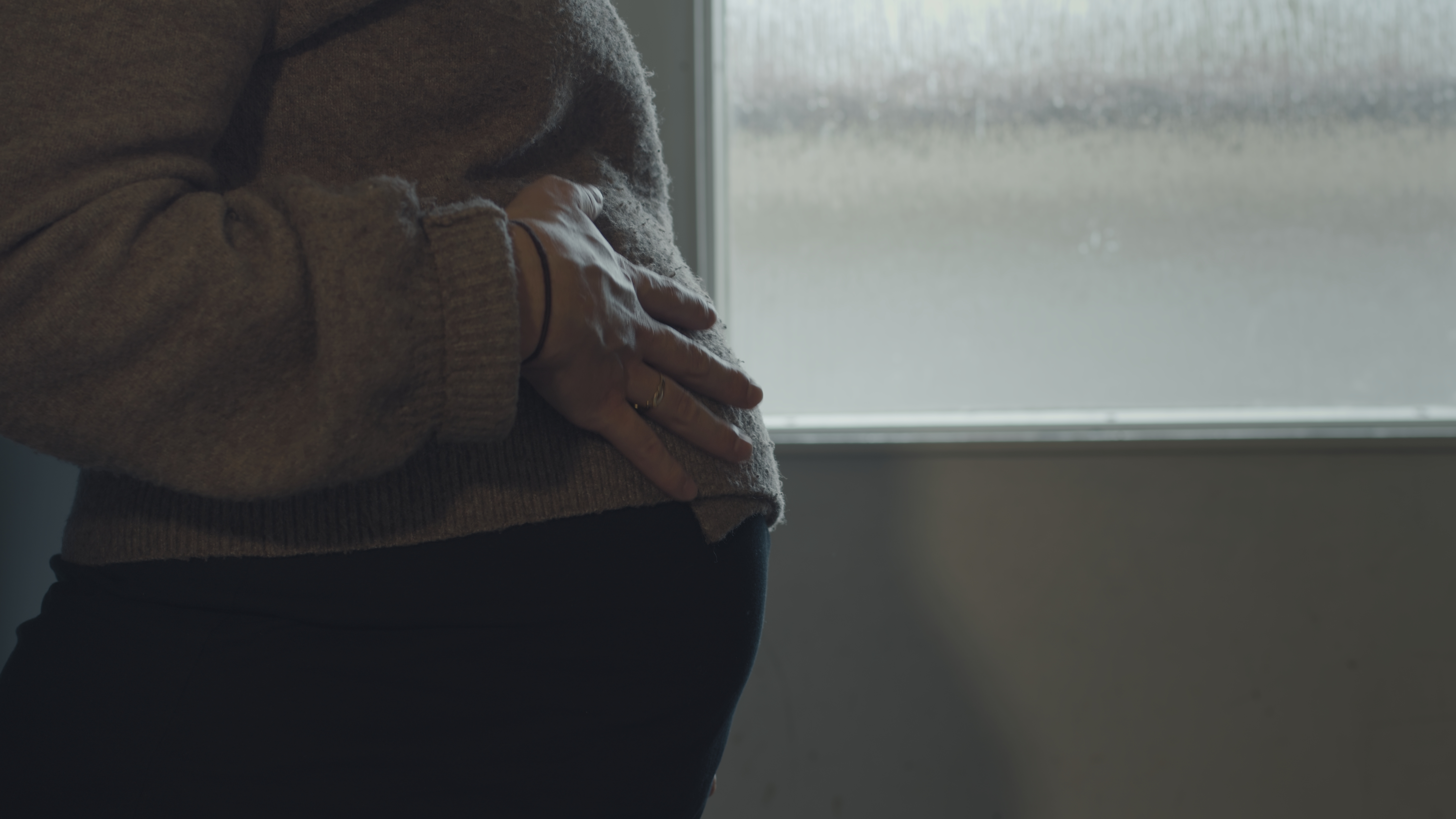 en gravid kvinna står vid en dörr