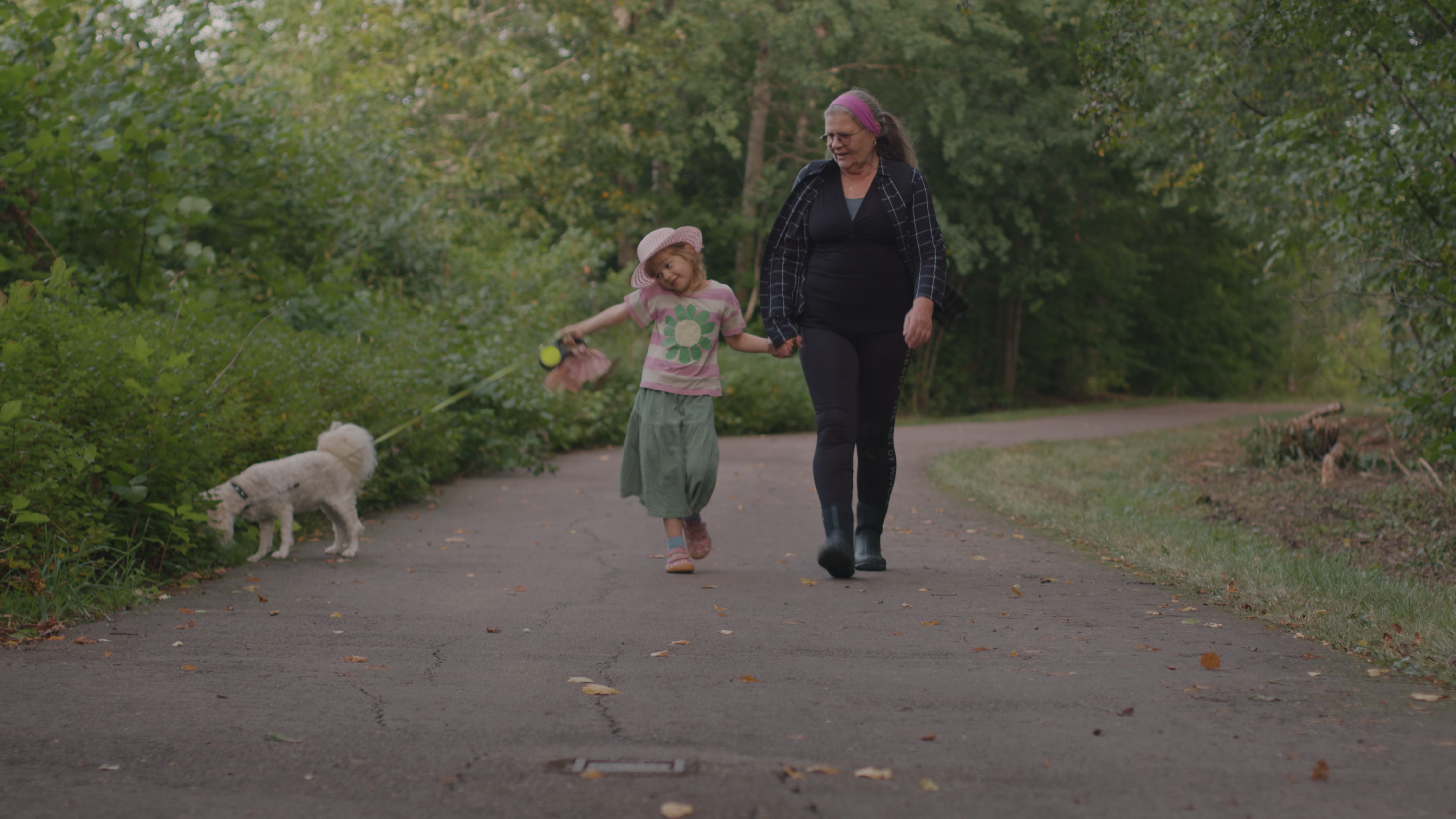 En kvinna, ett barn och en hund promenerar