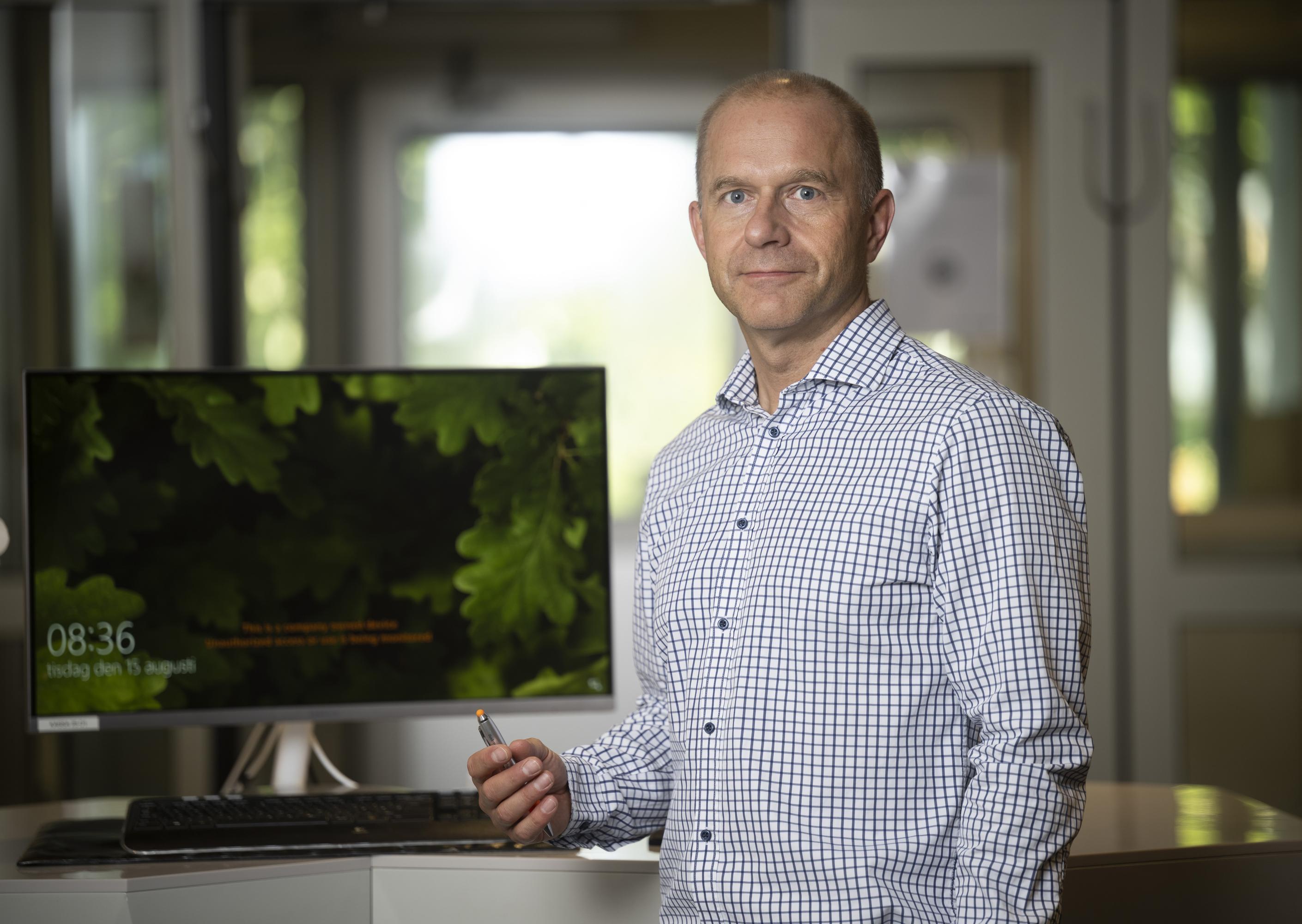 a man standing in front of a computor with a green screen