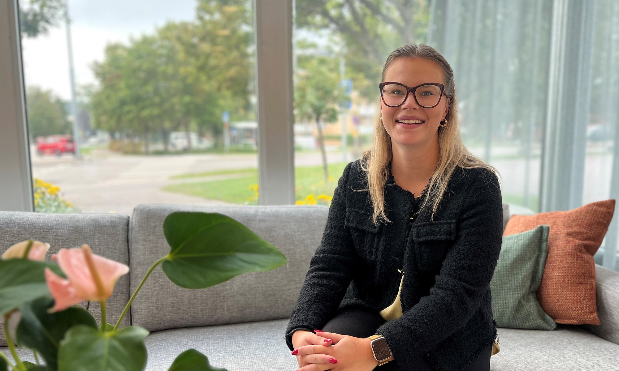 kvinna i svart kavaj ler mot kameran