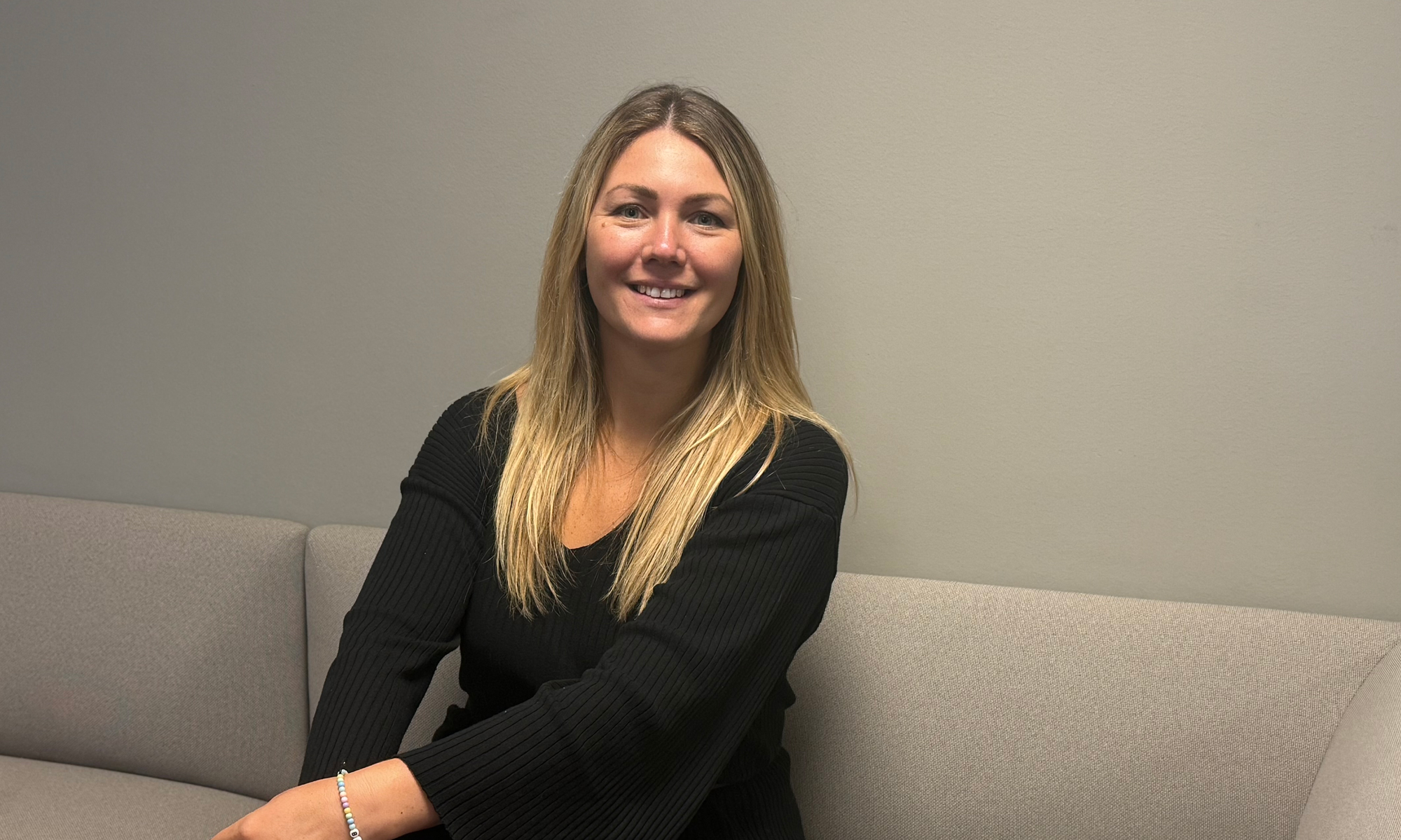 Kvinna klädd i svart sitter i en soffa