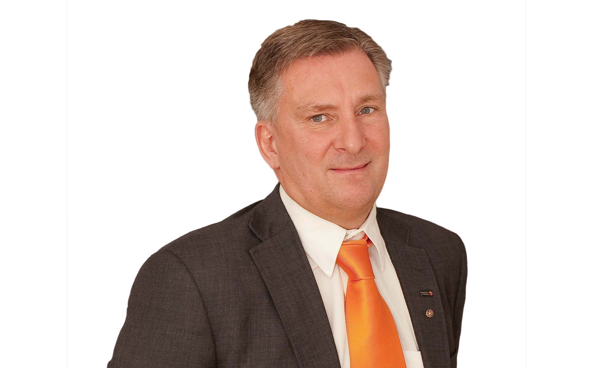 man in grey suit with white shirt and orange tie 