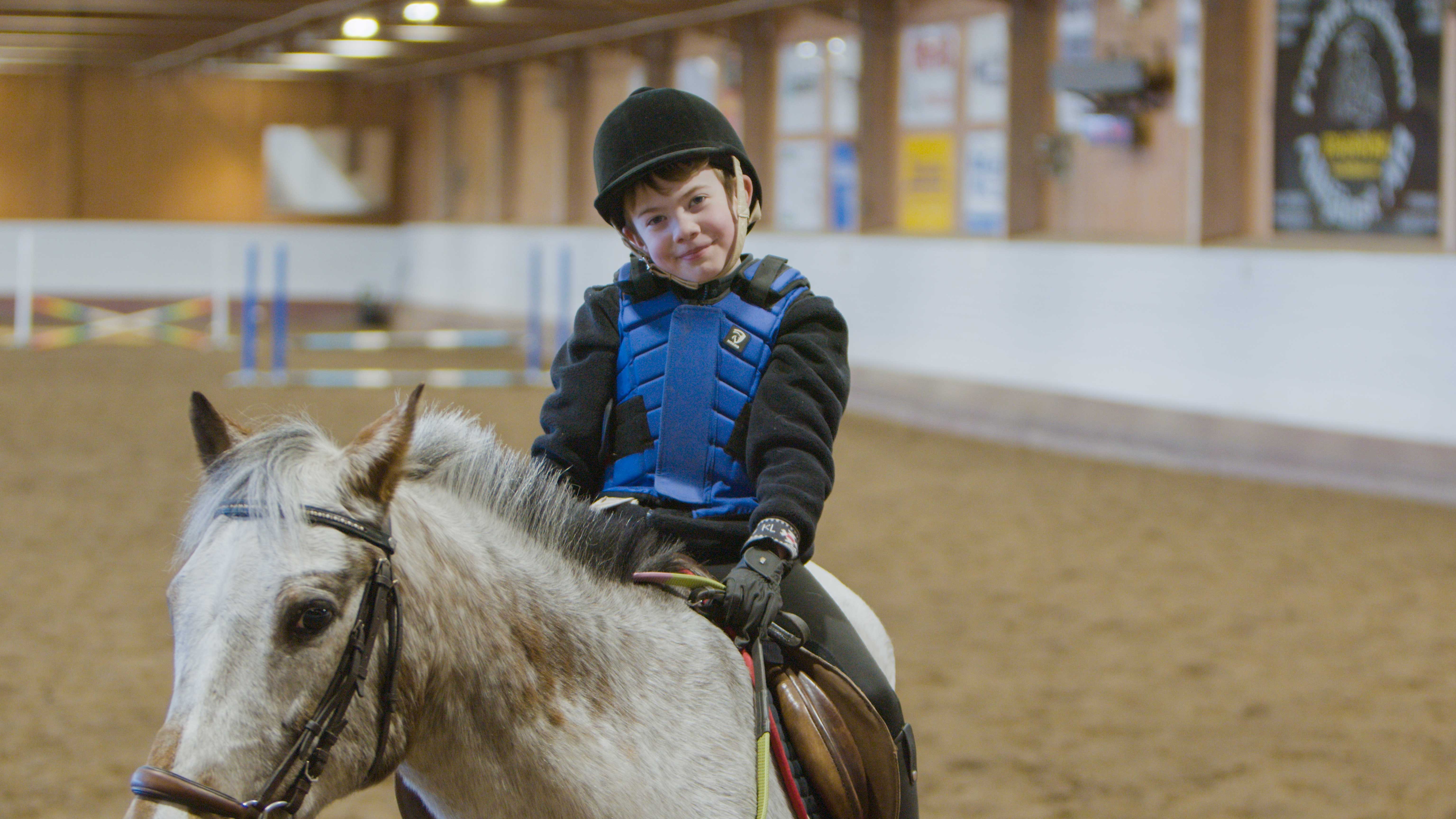 pojke sitter på en vit häst
