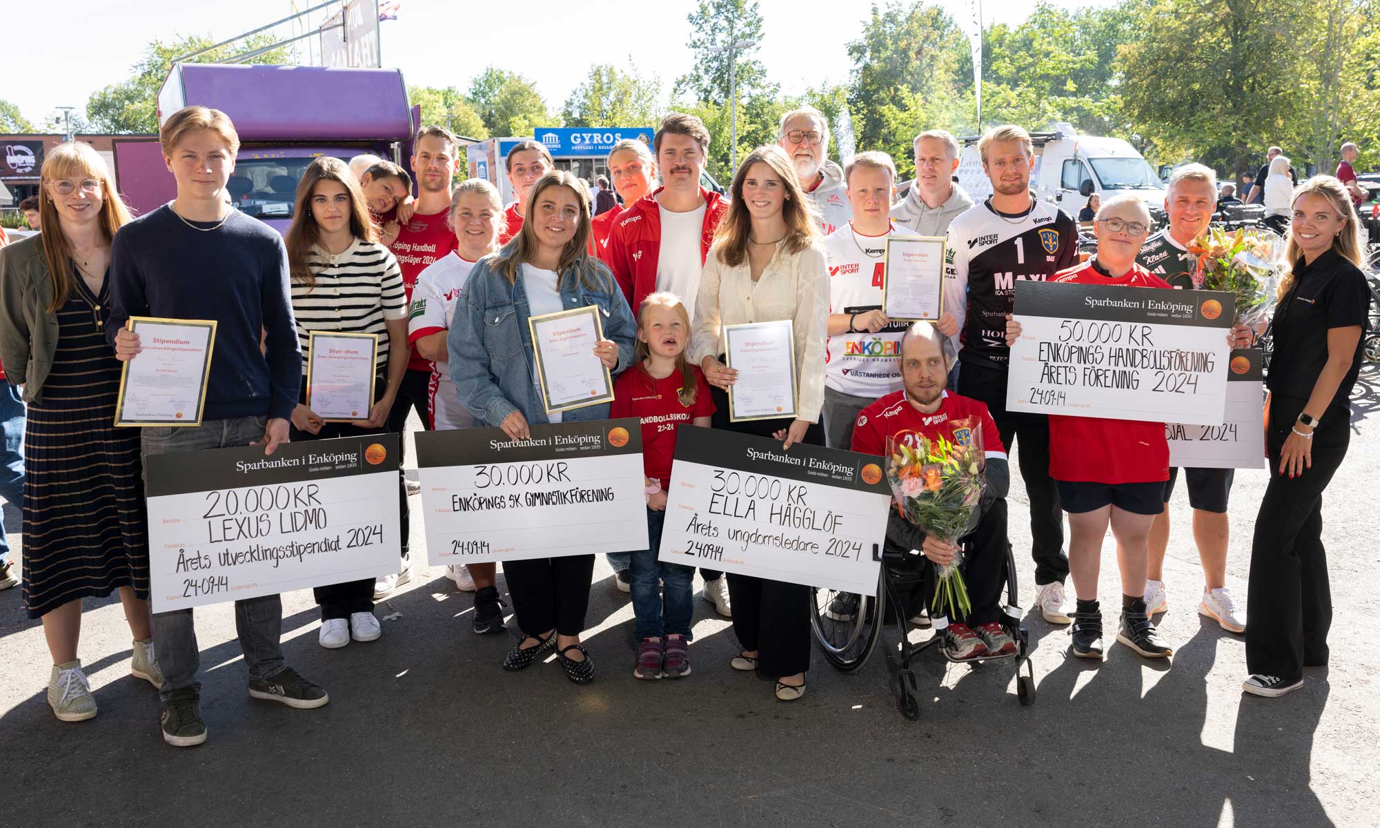 stipendiater som håller i stora checkar från Sparbanken i Enköping